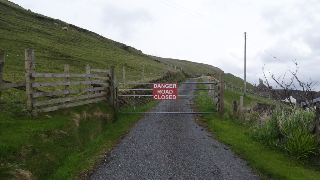 small road, fence with Danger Road Closed sign