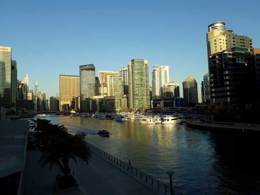 small boat crossing the water in Dubai Marina