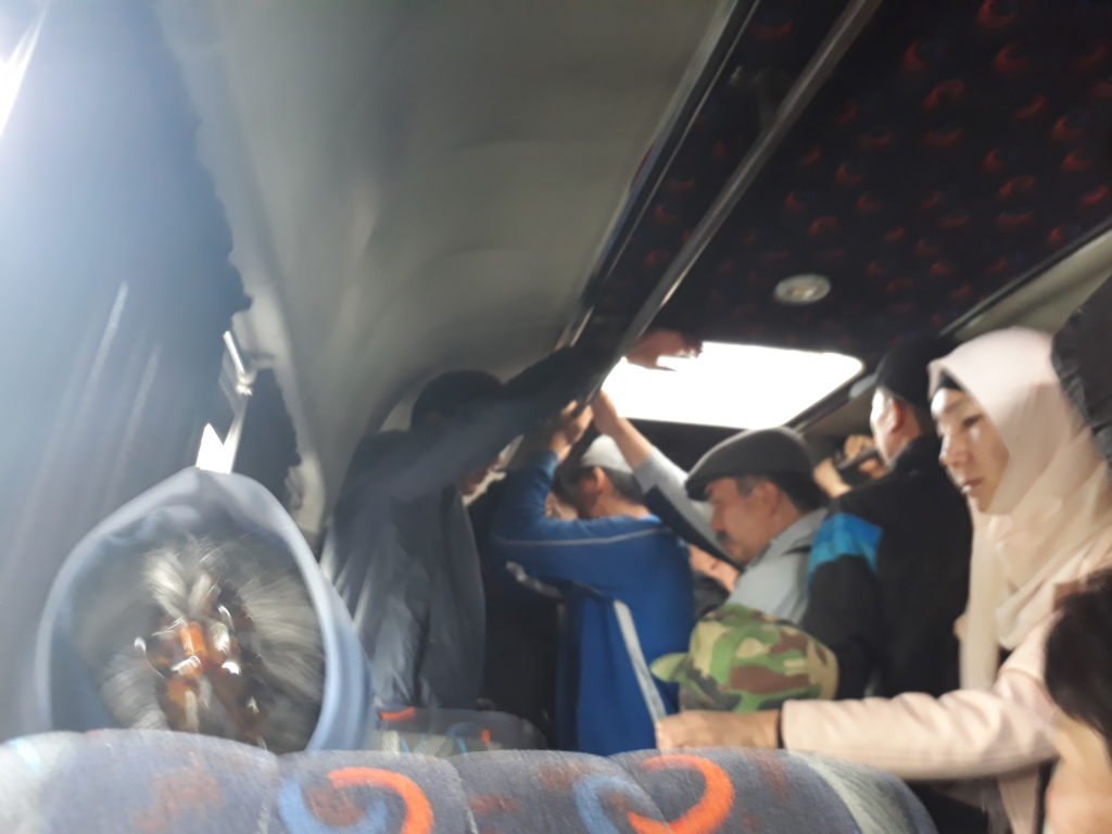 People standing in a packed minibus
